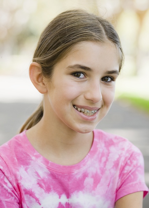 Preteen girl with interceptive orthodontics smiling