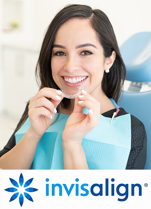 Smiling woman placing an Invisalign clear aligner tray