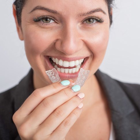 Woman placing her Invisalign tray